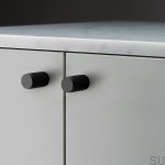 Zdjęcie mebla z gałką, wykonaną z czarnego metalu.