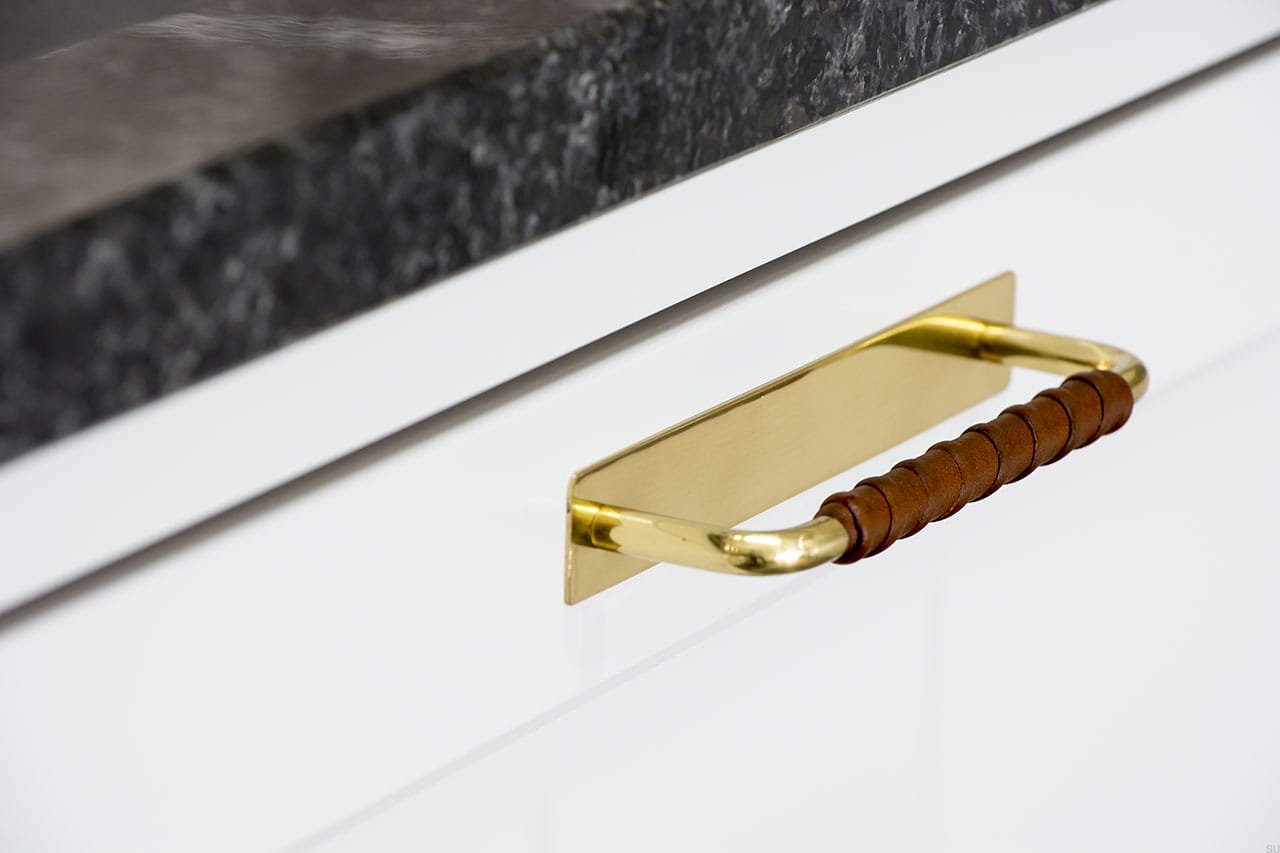 Zdjęcie przedstawia uchwyt meblowy podłużny z podstawą z serii  Royal Deluxe na meblu od Beslag Design